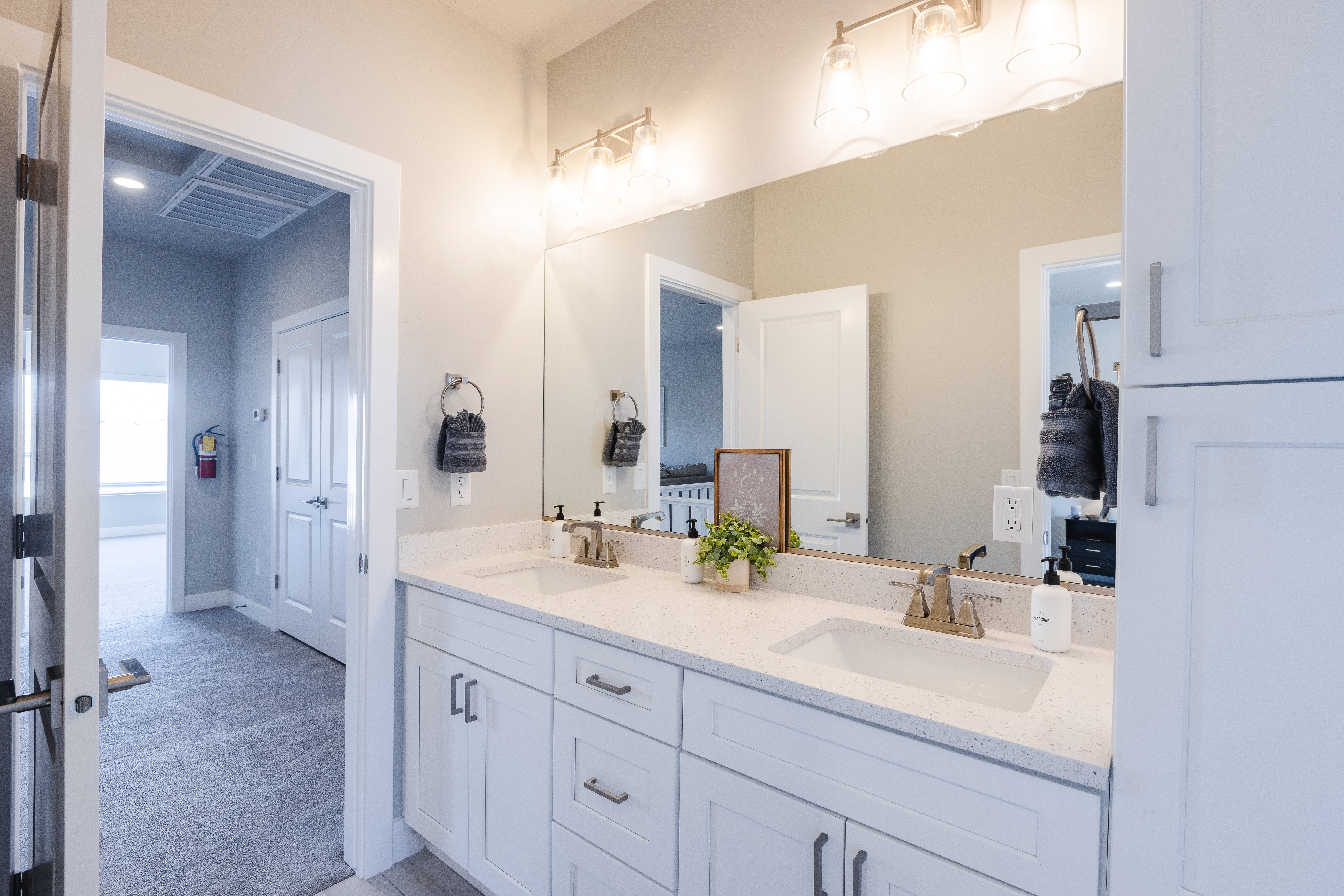 Full bathroom with double vanity and light colored carpet