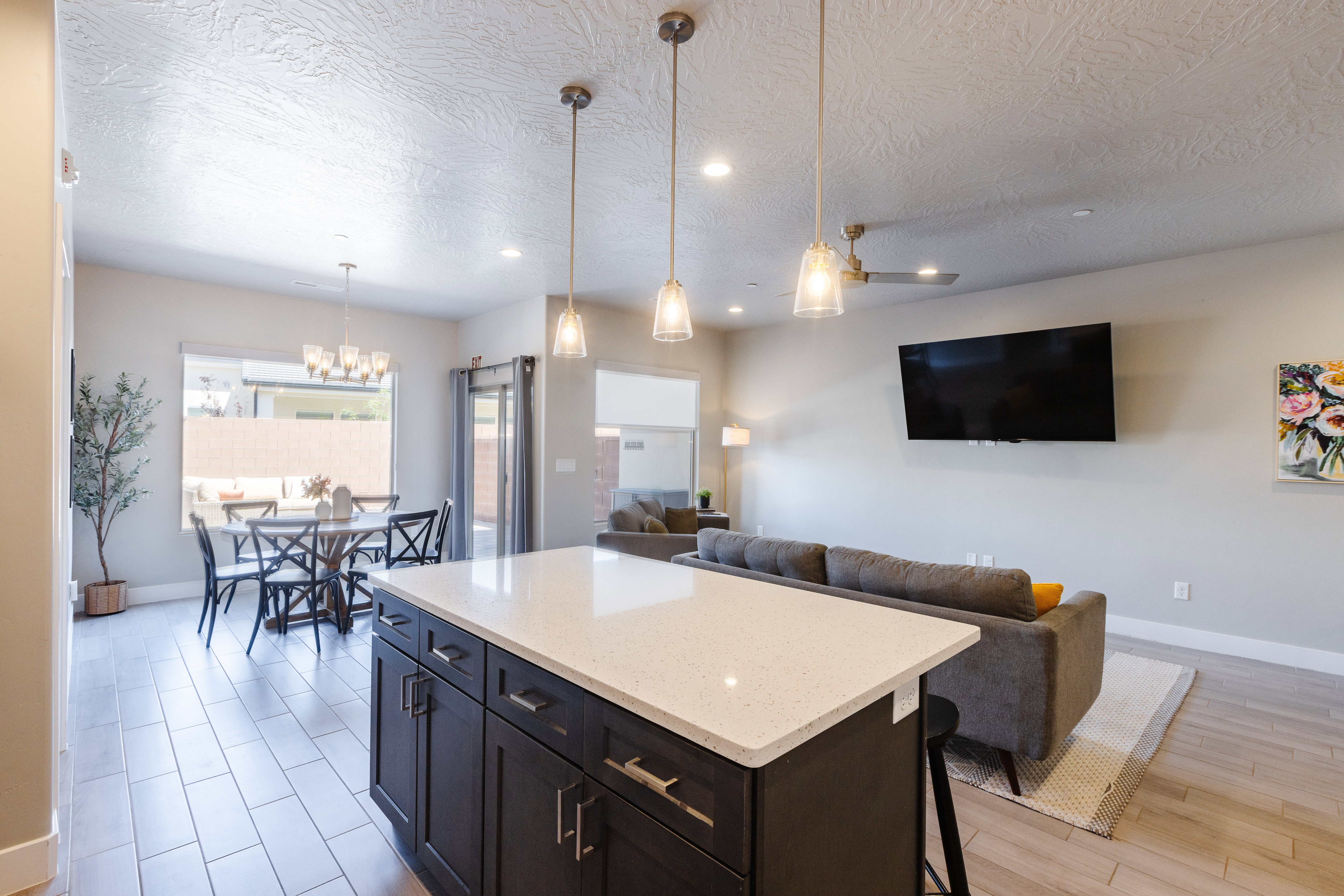 Kitchen with a center island, light stone counters, a kitchen breakfast bar, open floor plan, and a textured ceiling