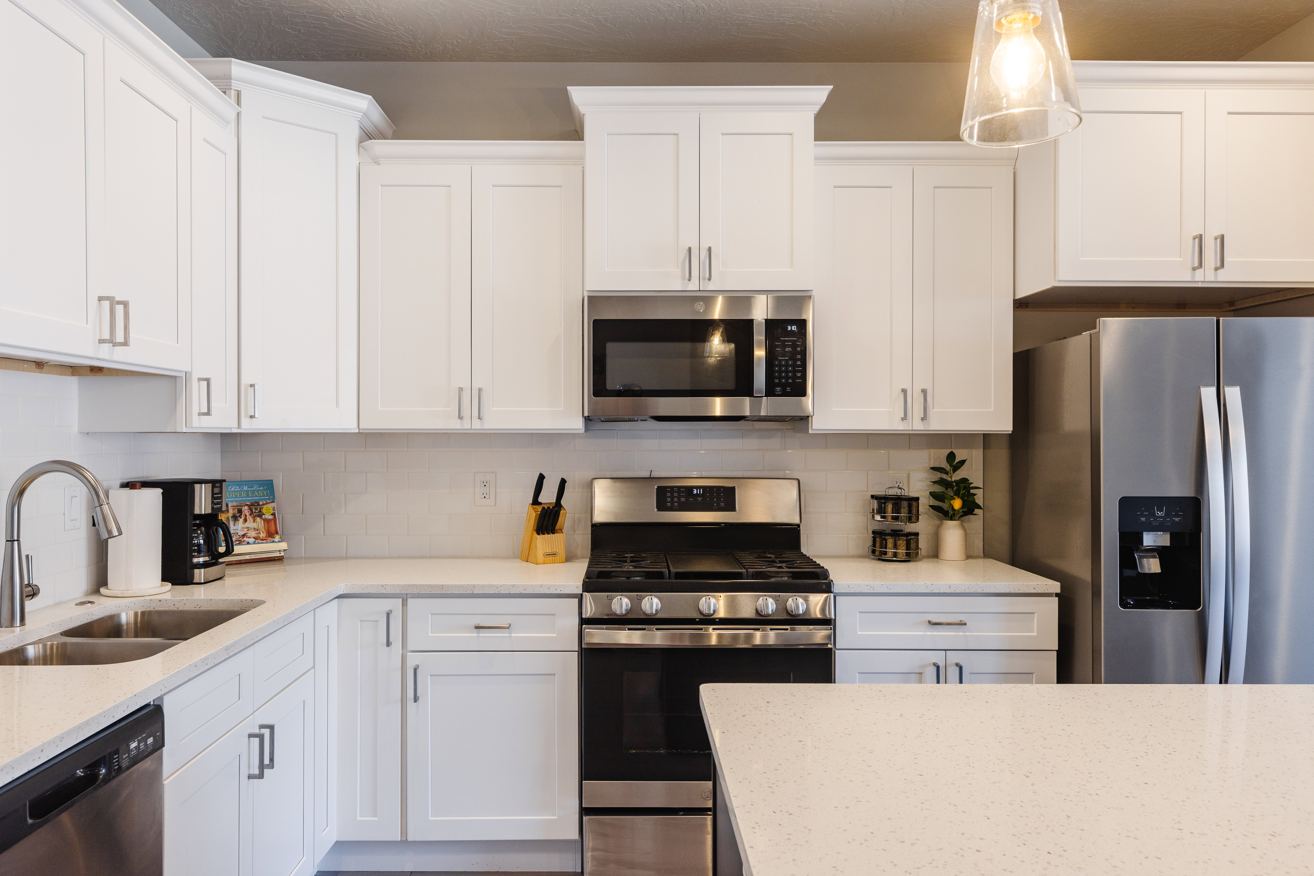 Kitchen with stainless steel appliances, white cabinets, and tasteful backsplash