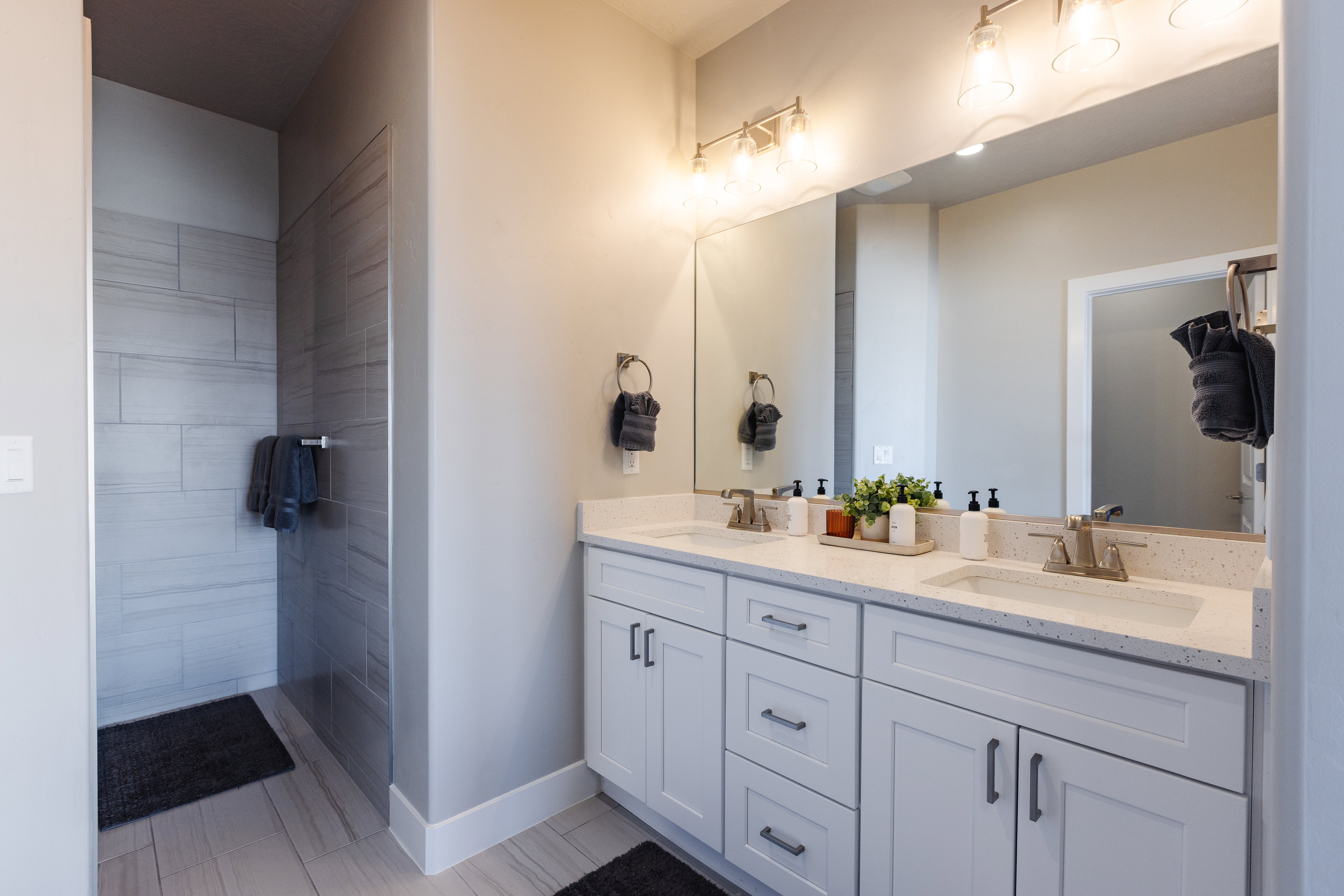 Full bathroom featuring double vanity and baseboards