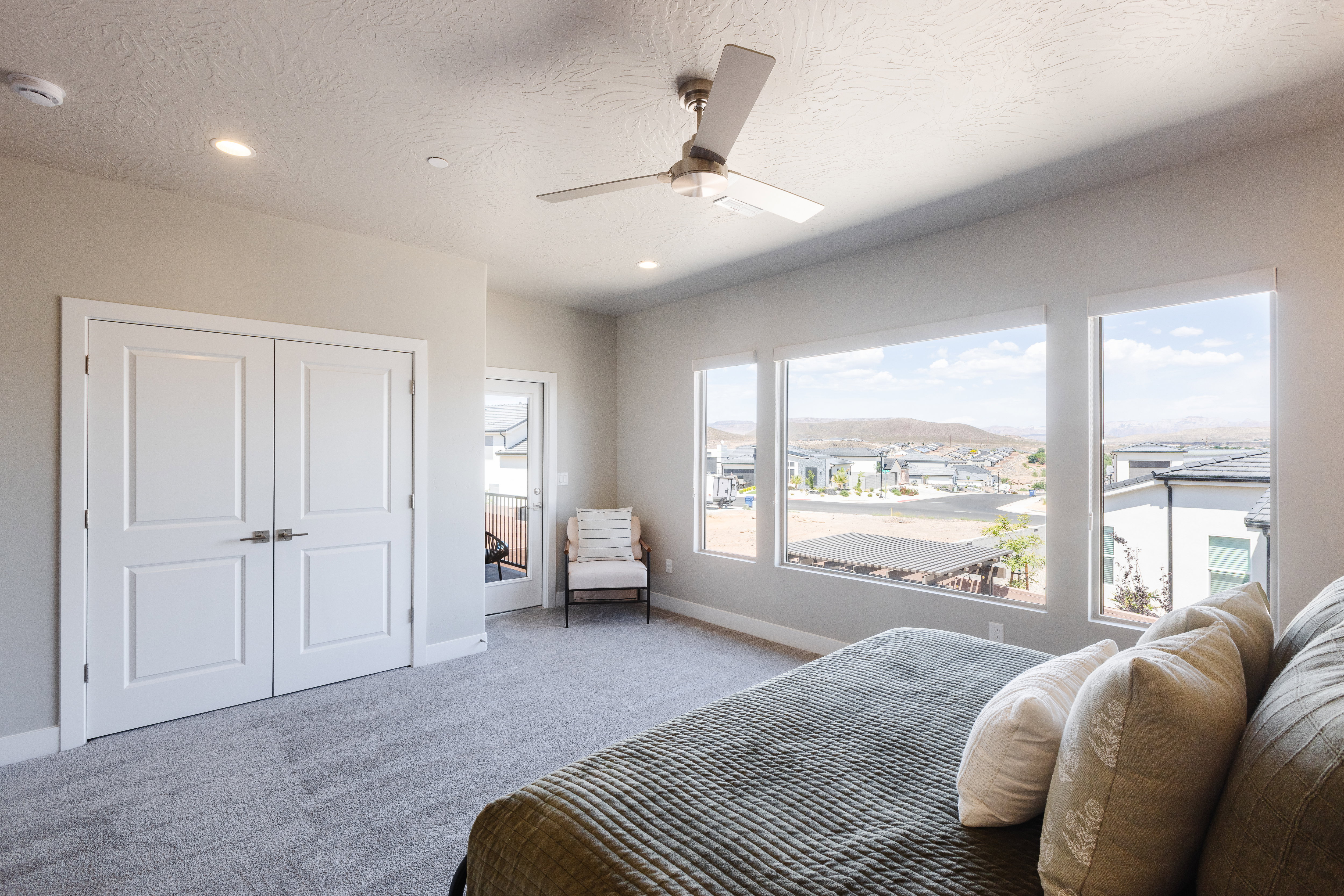 Carpeted bedroom with a ceiling fan, access to exterior, a mountain view, a textured ceiling, and recessed lighting