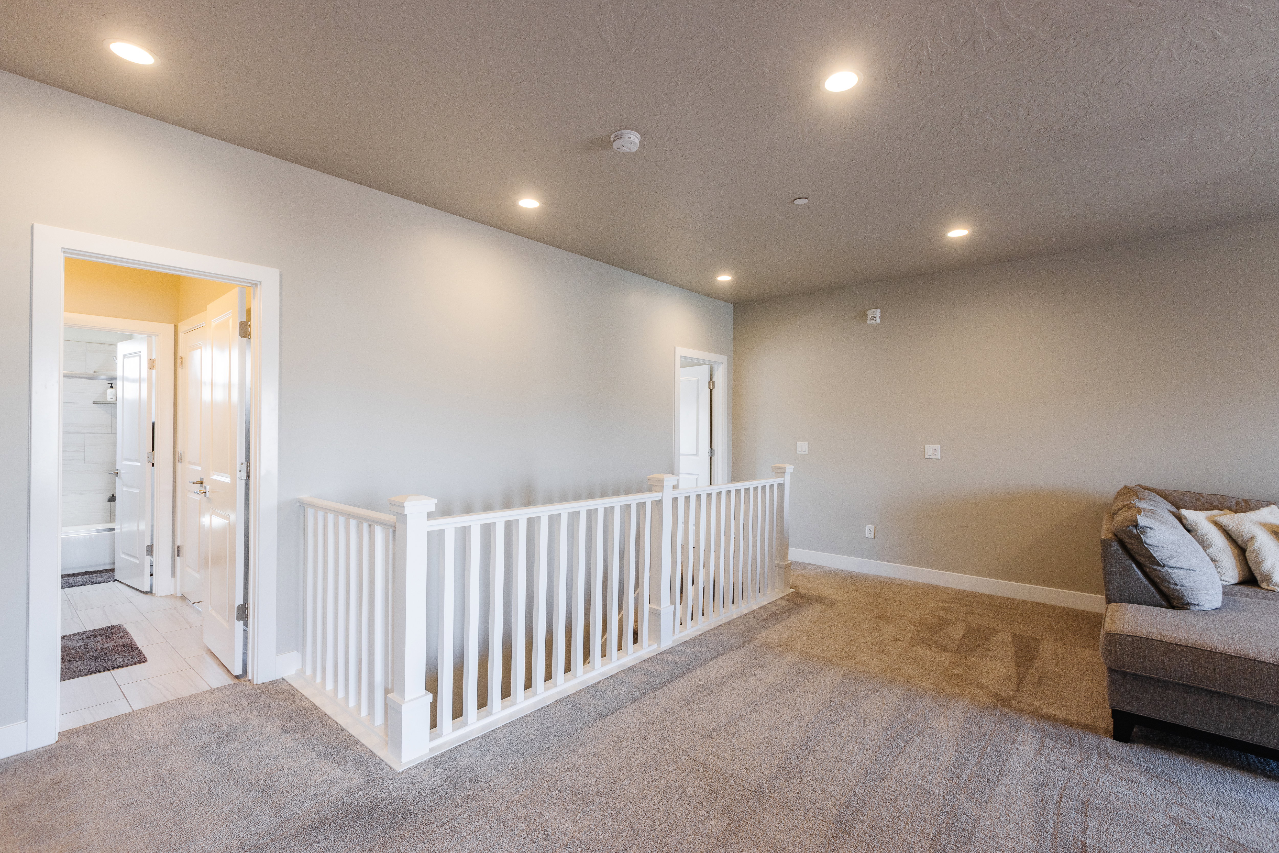 Living area with light colored carpet and recessed lighting
