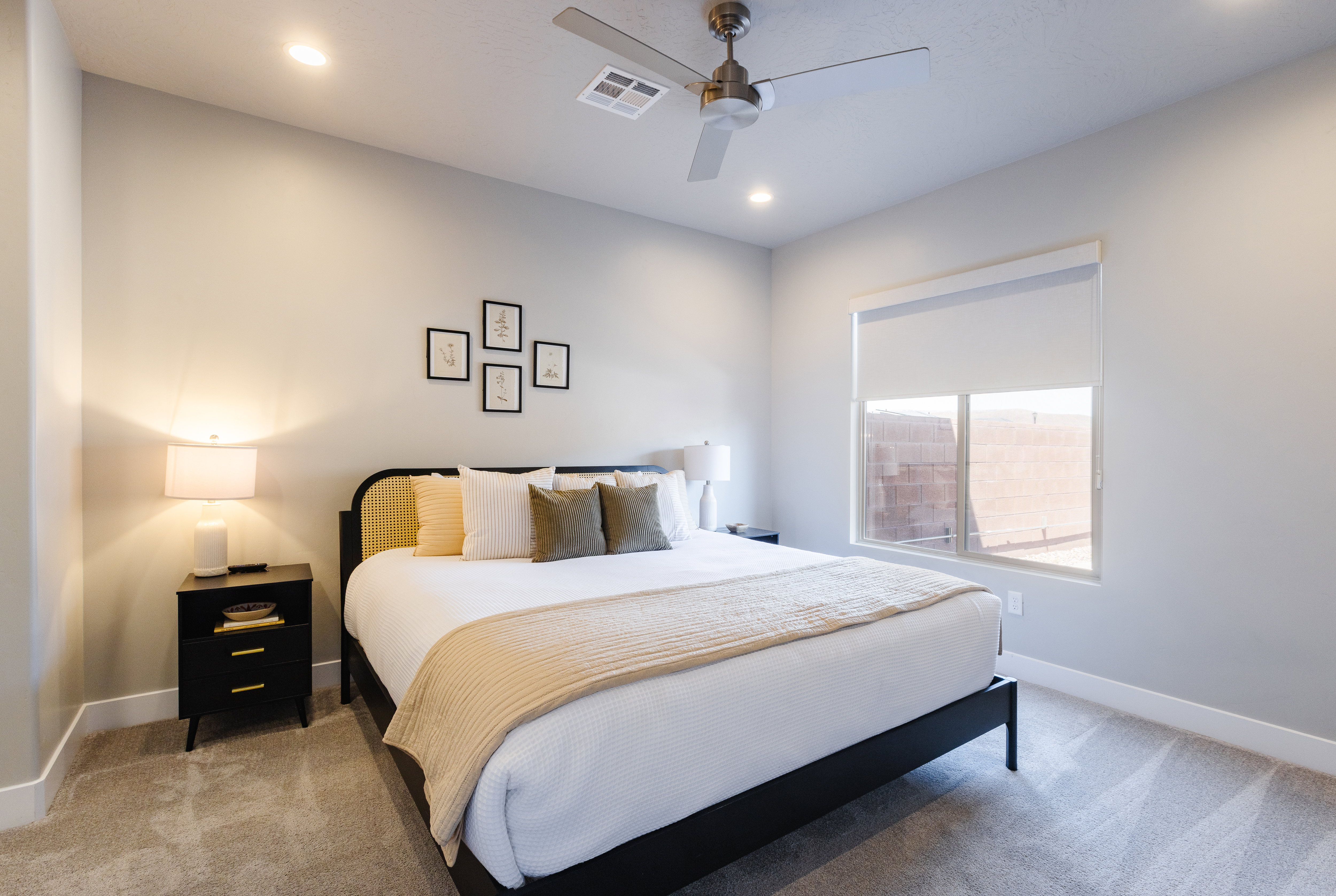 Carpeted bedroom with a ceiling fan and recessed lighting