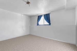 Spare room featuring carpet and a textured ceiling