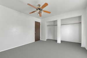 Unfurnished bedroom with carpet floors, multiple closets, and a ceiling fan