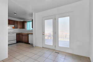 Kitchen with white appliances and light tile patterned floors