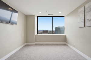Unfurnished room with light colored carpet and recessed lighting