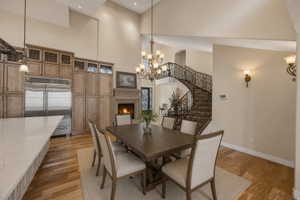 AI version of dining next to island. Dining area featuring a vaulted ceiling and wood-finish flooring