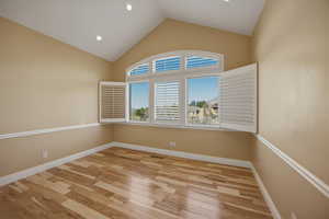Unfurnished room with light wood finished floors, vaulted ceiling, and recessed lighting