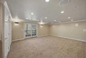 Basement featuring recessed lighting, light carpet, crown molding, and a textured ceiling