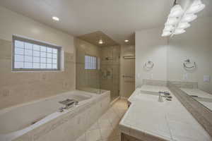 Full bathroom featuring a stall shower, vanity, a bath, light tile patterned flooring, and recessed lighting