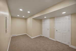 Finished basement with recessed lighting and carpet