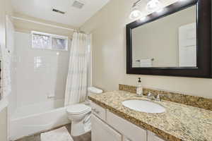 Full bath with vanity, shower / tub combo with curtain, and dark wood-style floors