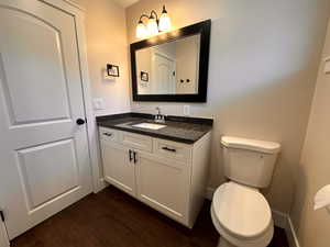 Half bath featuring vanity and dark wood-style flooring