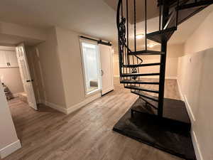 Staircase with wood finished floors and a barn door