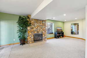 Living area featuring a stone fireplace and light colored carpet