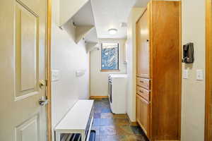Laundry room featuring stone tile flooring and washer and clothes dryer