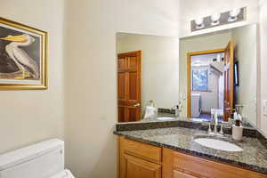 Half bath featuring vanity and a textured wall