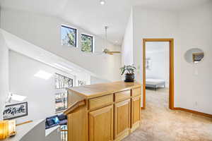 Hallway featuring recessed lighting, light carpet, and vaulted ceiling