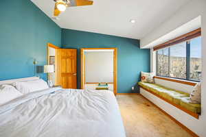 Bedroom featuring vaulted ceiling, light carpet, and a ceiling fan