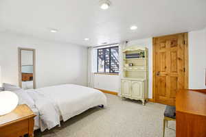 Carpeted bedroom with a textured ceiling and recessed lighting