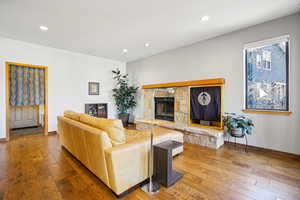 Living room featuring hardwood / wood-style floors, a fireplace, and recessed lighting