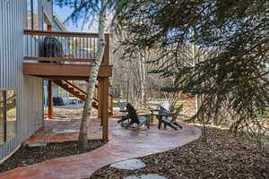 View of patio / terrace with an outdoor fire pit and a deck