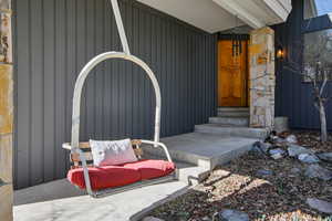Doorway to property featuring covered porch