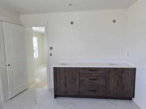 Full bath with double vanity and light marble finish floors