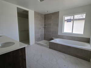 Full bathroom with a bath, double vanity, a tile shower, and a textured ceiling