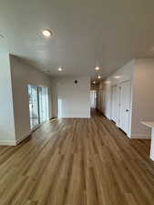 Unfurnished living room featuring recessed lighting, light wood-style floors, and a textured ceiling