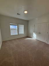 Unfurnished bedroom with carpet flooring, a closet, and a textured ceiling