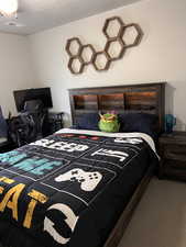 Bedroom with carpet flooring, a textured ceiling, and a ceiling fan