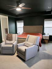 Mater bedroom with ceiling fan and seating area