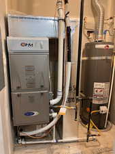 Utility room featuring secured water heater and heating unit