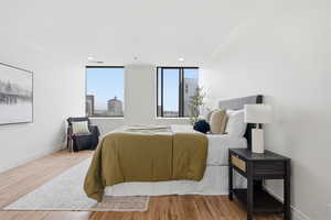 Bedroom with light wood-type flooring, crown molding, and recessed lighting