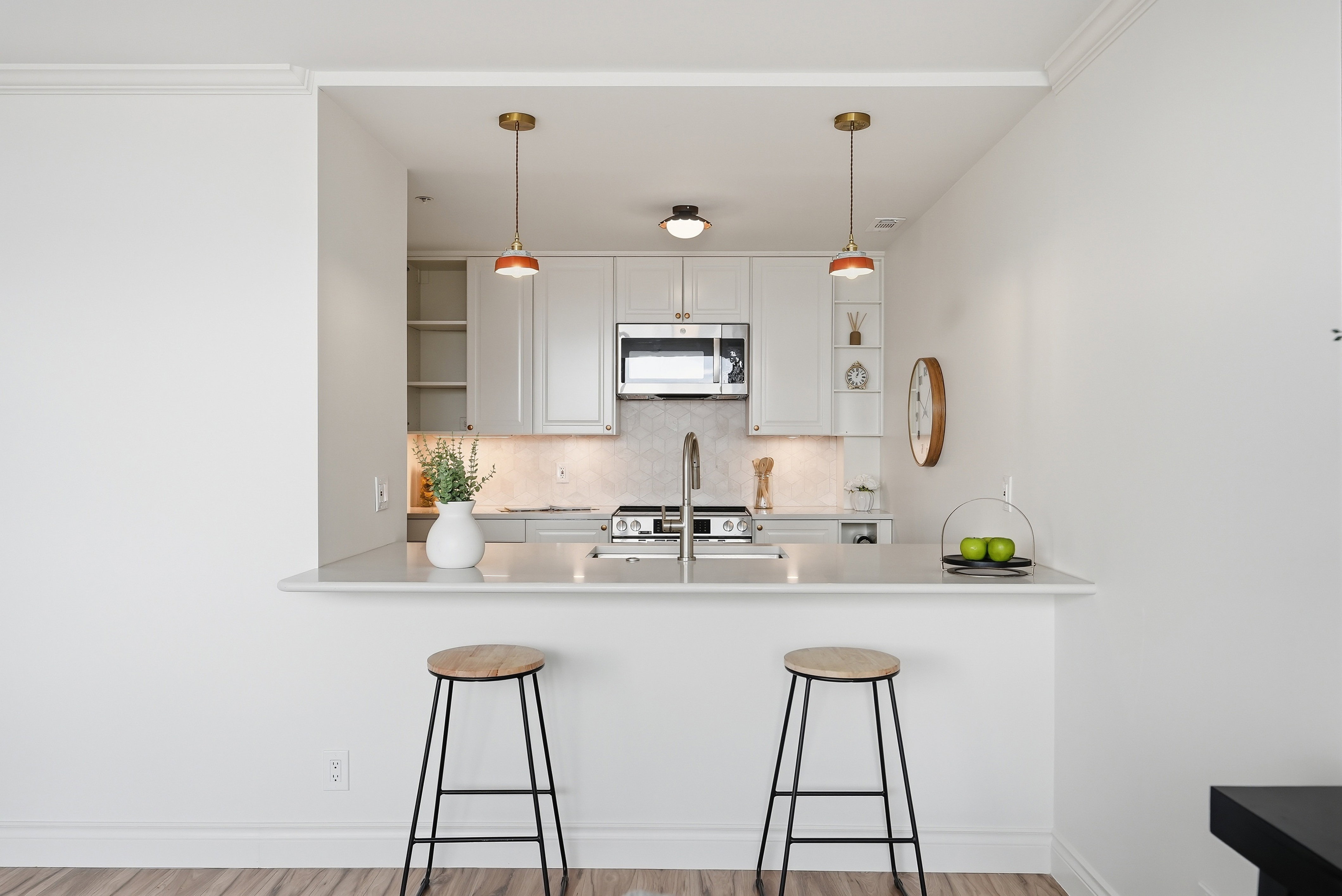 Kitchen featuring open shelves, a kitchen breakfast bar, white cabinetry, a peninsula, and pendant lighting