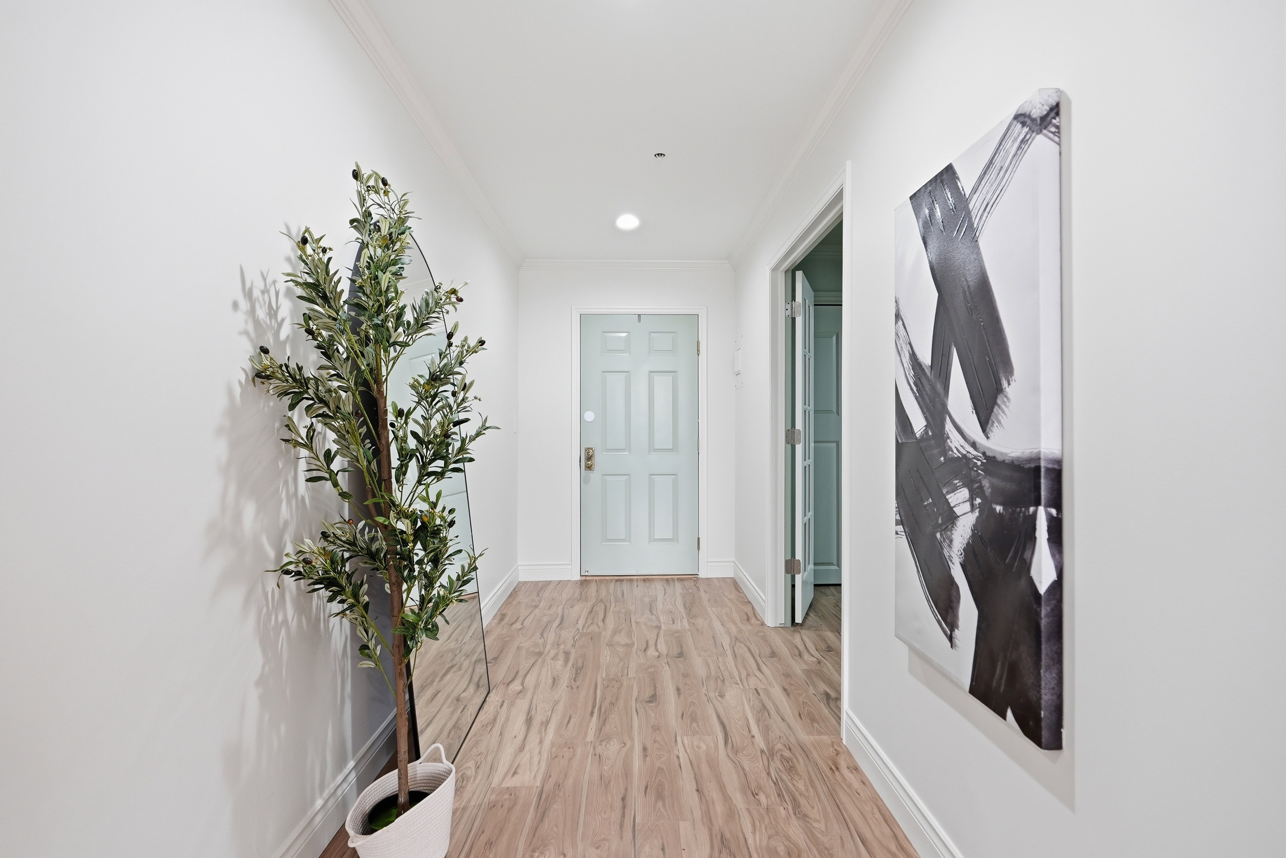 Hallway featuring light wood finished floors, recessed lighting, and ornamental molding