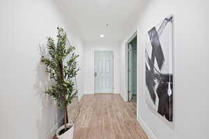 Hallway featuring light wood finished floors, recessed lighting, and ornamental molding
