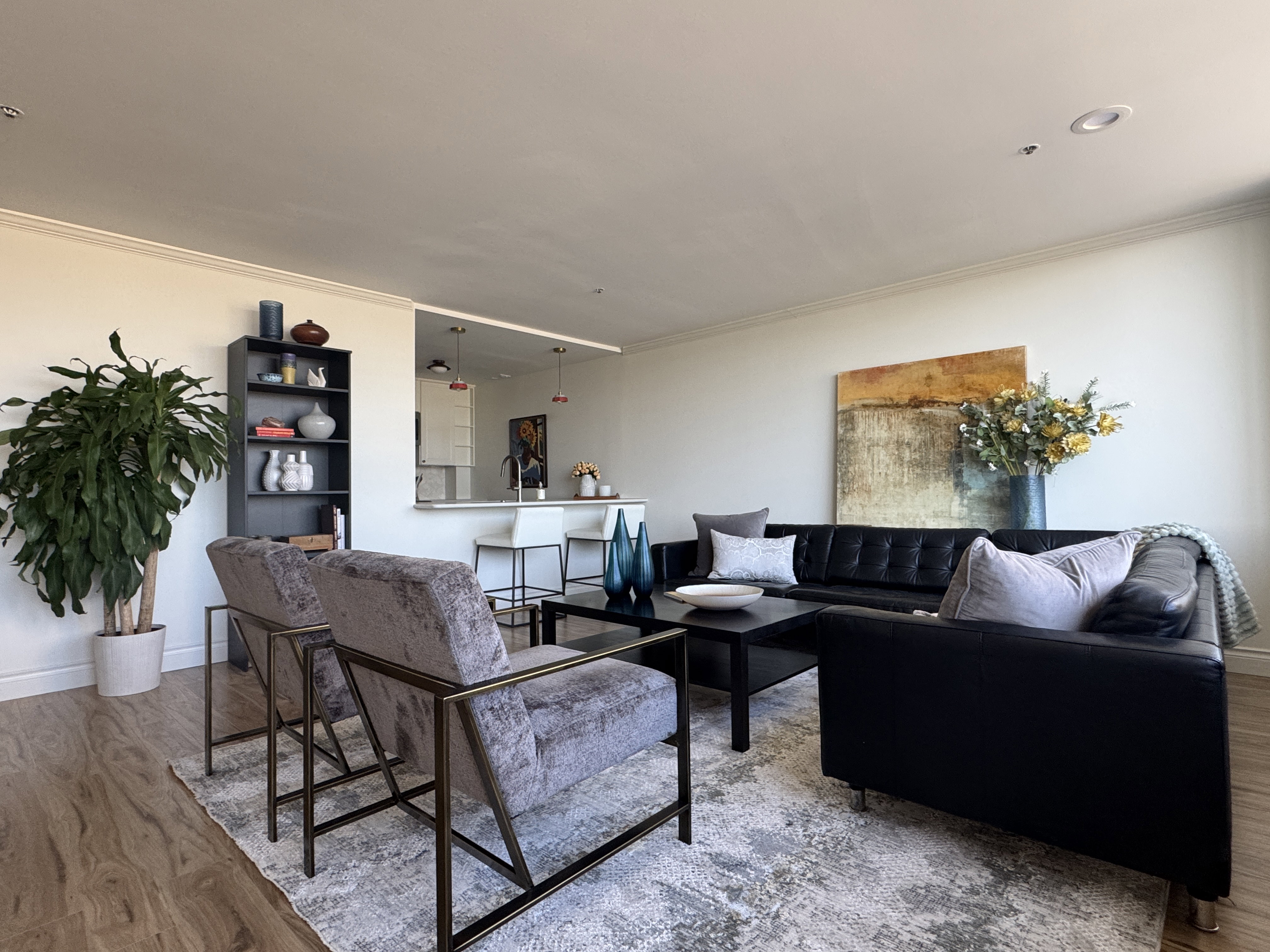 Open-concept living area featuring wood-finish flooring, recessed lighting, and crown molding