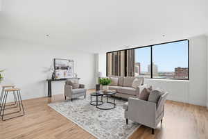 Living room featuring light wood-style floors and crown molding
