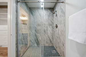 Full bathroom with a marble finish shower