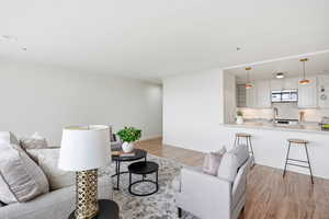 Living area with light wood-type flooring and crown molding