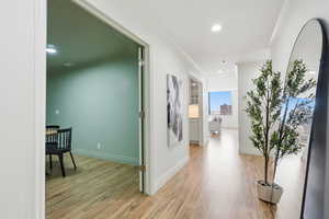 Corridor featuring recessed lighting, light wood-style floors, and ornamental molding