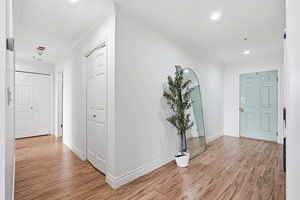Entryway with light wood-style flooring, ornamental molding, and recessed lighting
