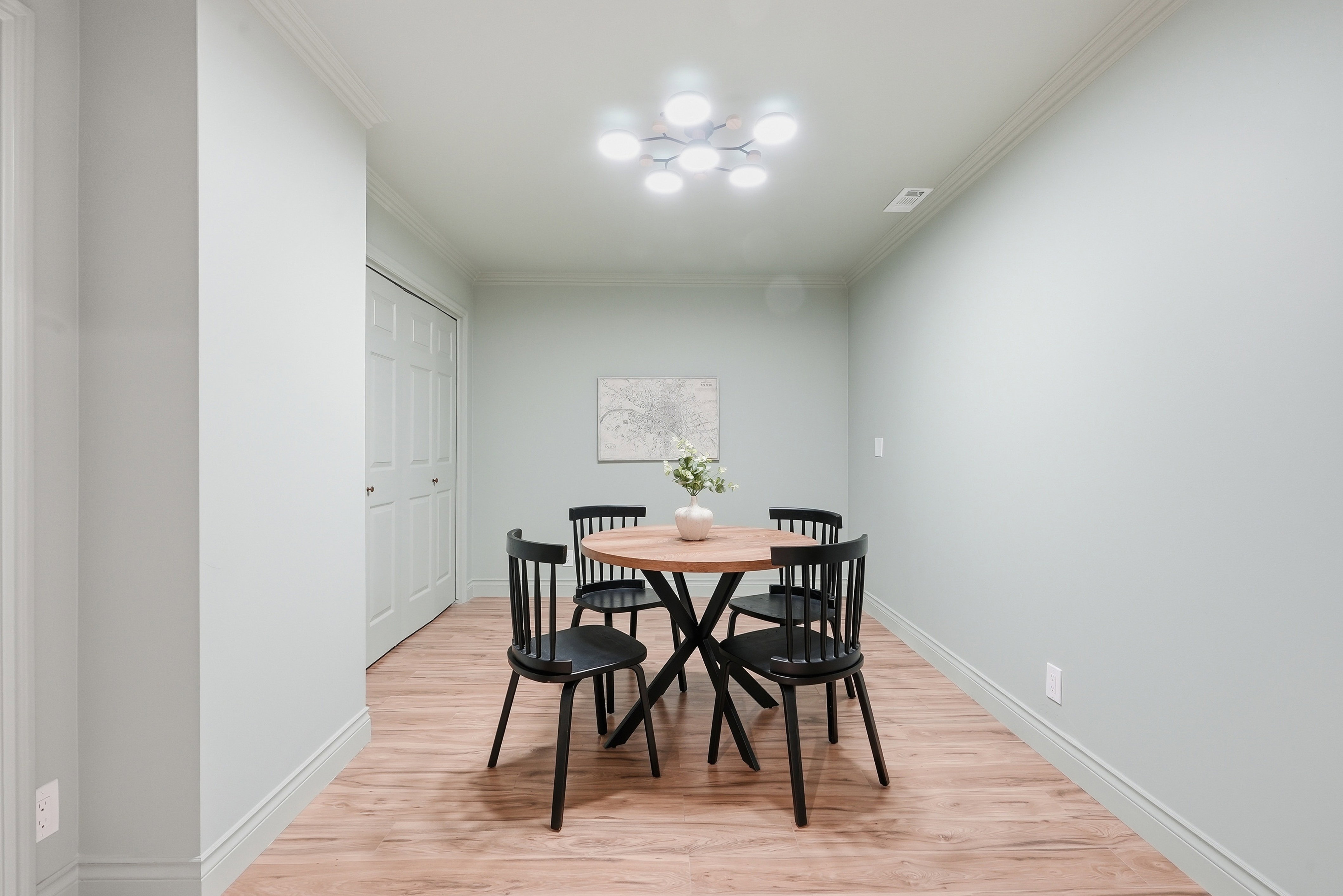 Dining room with light wood finished floors and crown molding