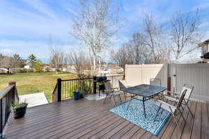 Deck featuring outdoor dining space, a yard, a residential view, and grilling area