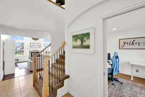 Stairs with a tile fireplace and baseboards