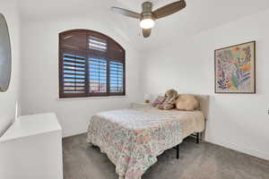 Bedroom with vaulted ceiling, carpet floors, and ceiling fan