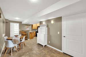 Kitchen featuring light countertops, black appliances, and hanging light fixtures